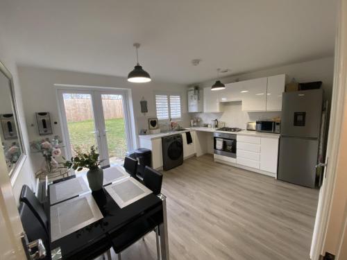 cocina grande con armarios y electrodomésticos blancos en Modern Home Birtley en Birtley