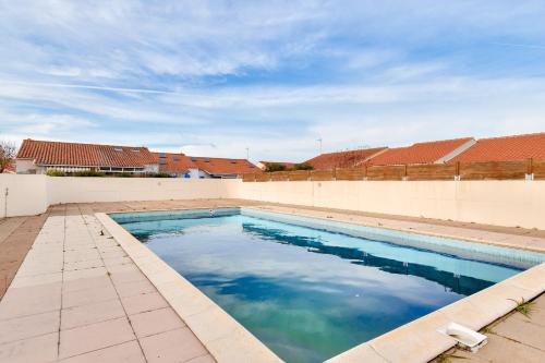 une piscine sur le côté d'un immeuble dans l'établissement Maison moderne et piscine commune, à Les Sables-dʼOlonne