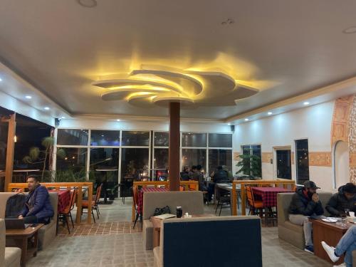 un restaurante con mesas y una gran lámpara de araña en Pork Hub en Pātan