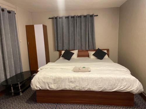1 dormitorio con 1 cama grande con sábanas blancas en Pork Hub en Pātan