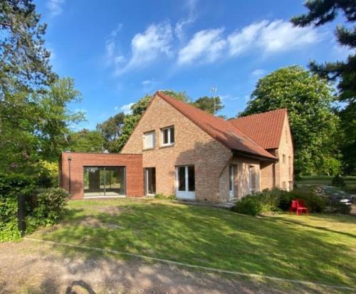 een groot bakstenen huis op een grasveld bij Vaste villa proche golf du Touquet in Cucq