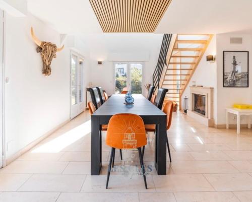 a dining room with a black table and chairs at Vaste villa proche golf du Touquet in Cucq