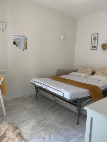 una cama en una habitación con una pared blanca en Estudio Golf & BEACH, en Mijas Costa