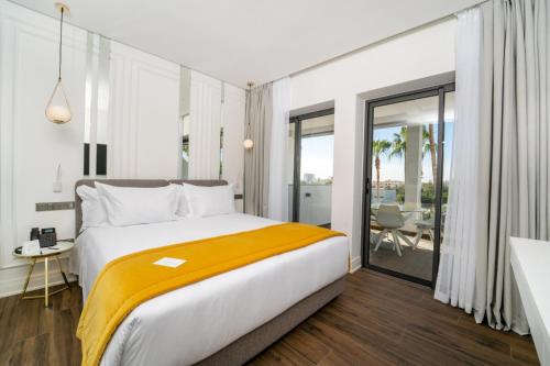 a bedroom with a large bed with a yellow blanket at Petit Palace Suites Hotel in Agadir
