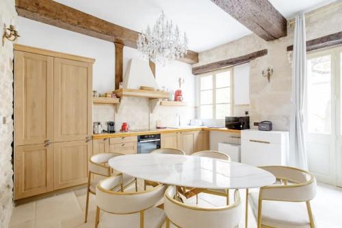 a kitchen with a white table and chairs at Le Clos Des Vosges in Paris