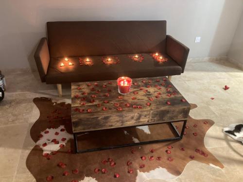 una mesa de centro con velas y pétalos en el suelo en La nuit glamour, en Herblay