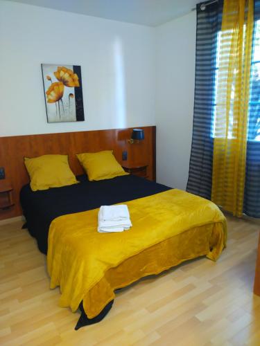 a bedroom with a large bed with a yellow blanket at Le Castel d'olmes in Laroque-dʼOlmes