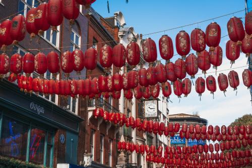 un montón de faroles chinos rojos colgando sobre una calle en Be London - Chinatown Residences, en Londres