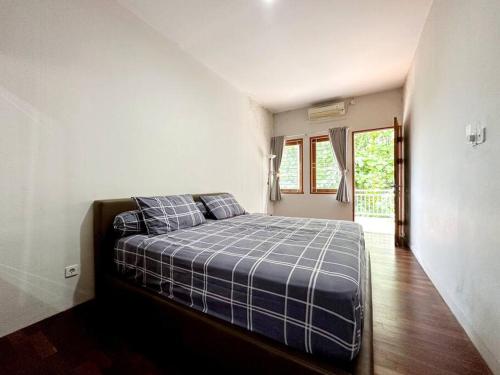 um quarto com uma cama num quarto com uma janela em Villa Blue Saphire Sanur Mansion em Denpasar