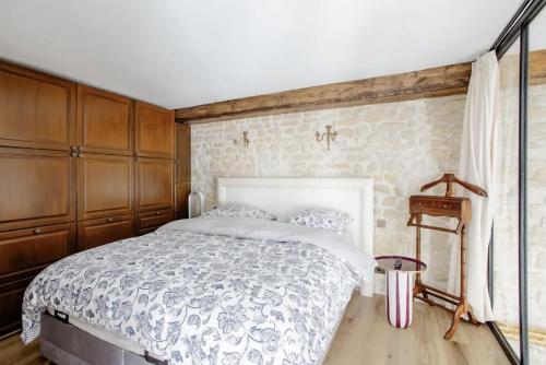 a bedroom with a bed and wooden cabinets at Le Clos Des Vosges in Paris