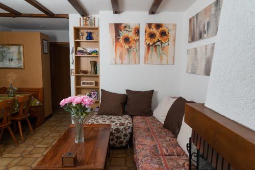 a living room with a couch and flowers on a table at Pic Chaussy A2 in Les Mosses