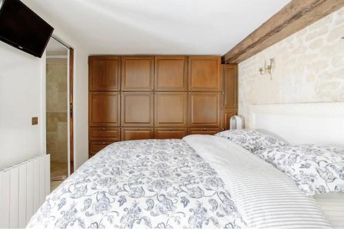 a bedroom with a large bed and a television at Le Clos Des Vosges in Paris