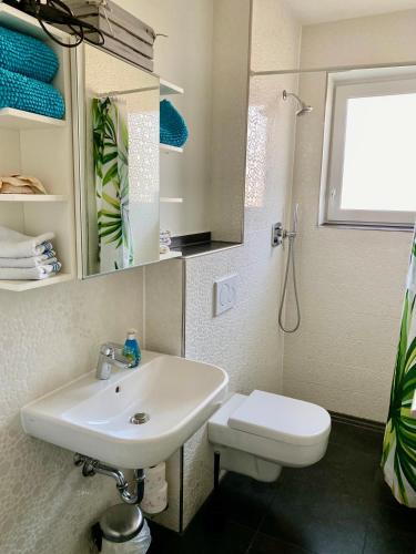 a white bathroom with a sink and a toilet at Zimmer am Bachlauf in Gelsenkirchen