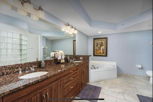 baño con 2 lavabos y espejo grande en Oceanfront Beautiful Paradise en Daytona Beach