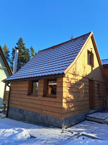 a log cabin with a shingle roof at Chata TRI GROŠE 2 in Námestovo