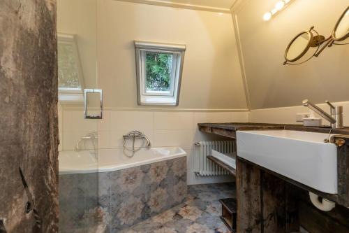 ein Badezimmer mit einer Badewanne und einem Waschbecken in der Unterkunft Appartement - Valkenisseweg 68 l Biggekerke 'Strand Appartement' in Biggekerke