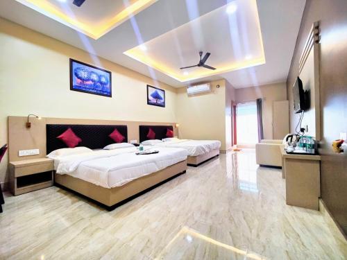 um quarto com 2 camas e uma televisão de ecrã plano em GRACE INN GUEST HOUSE, Near Airport and Ion Digital em Guwahati