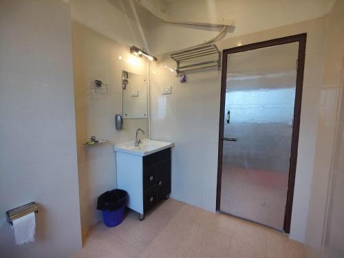 a bathroom with a sink and a mirror and a door at GRACE INN GUEST HOUSE, Near Airport and Ion Digital in Guwahati