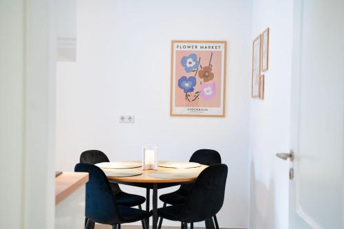 una mesa de comedor con sillas negras alrededor en Gemütliches Design Appartment in Wolfsburg en Wolfsburg