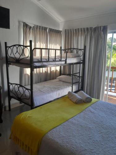 2 łóżka piętrowe w pokoju z oknem w obiekcie Indaba Manor Guesthouse w mieście Port Edward