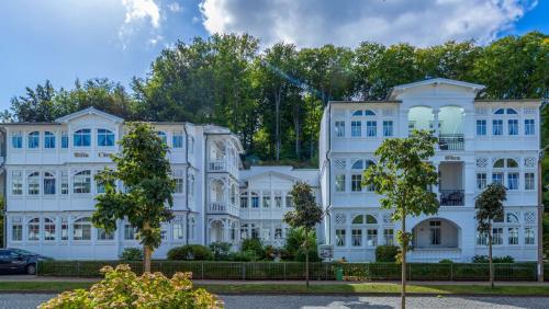 ein weißes Gebäude mit Bäumen davor in der Unterkunft Ferienwohnung 1 Villa Eden in Binz
