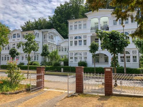 einen Zaun vor einem weißen Gebäude in der Unterkunft Ferienwohnung 1 Villa Eden in Binz