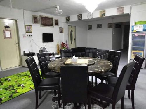 einen Konferenzraum mit einem Tisch und Stühlen sowie einem TV in der Unterkunft Airport Kota Bharu Homestay & Riverview Inn in Kota Bharu