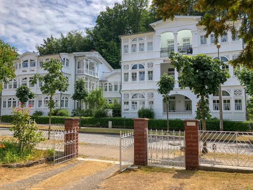 a fence in front of a white building at Ferienwohnung 11 Villa Eden in Binz
