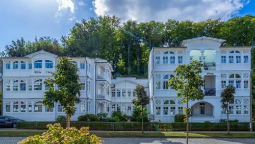 a white building with trees in front of it at Ferienwohnung 17 Villa Eden in Binz
