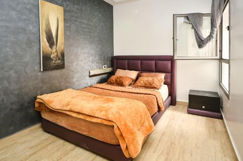 1 dormitorio con 1 cama grande y espejo en Sunny Modern 1BR in Belvedere en Casablanca