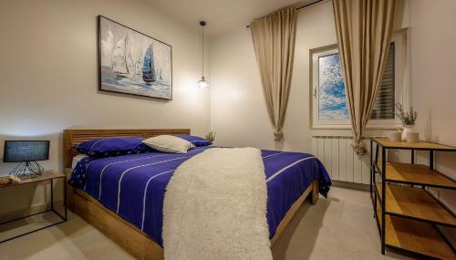 Schlafzimmer mit einem Bett mit blauer Decke in der Unterkunft New ! Luxury villa Euphoria with heated infinity pool in Solin