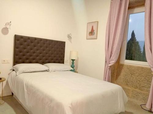 Ribarteme的住宿－CASA CANDIDO，一间卧室设有一张大床和一个窗户。