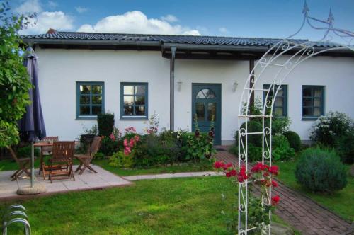 una casa bianca con tavolo e sedie in cortile di Fewo Katja im Ostseebad Binz a Binz