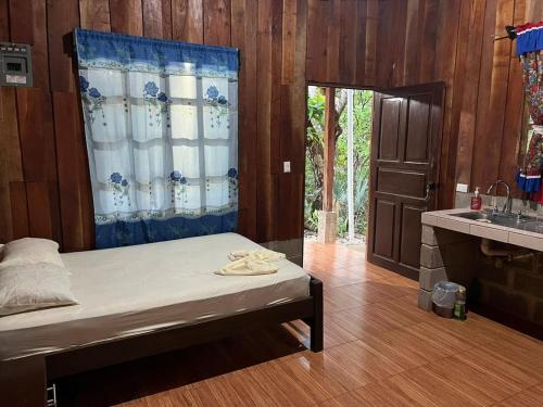 a bedroom with a bed and a kitchen with a sink at Cabañas Hospedaje la Reserva in Hojancha