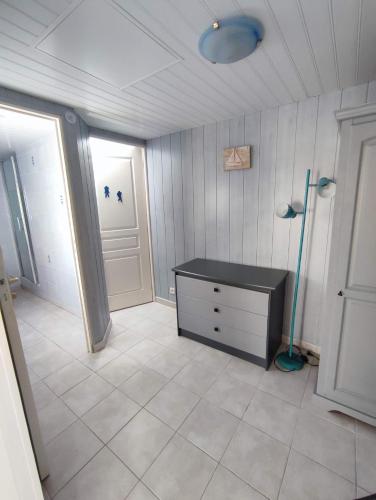 une salle de bain avec une commode noire et une fenêtre dans l'établissement Petite Maison des Demoiselles, à Saint-Hilaire-de-Riez
