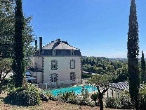 an external view of a villa with a swimming pool at Maison d'hôtes et gîtes La Chouannerie à côté du parc du Puy duFou in Pouzauges