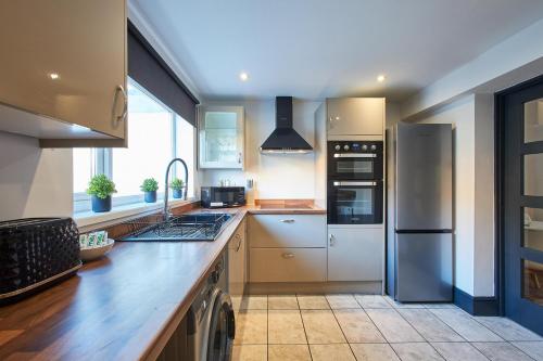 a kitchen with stainless steel appliances and a large window at Host & Stay - North Shore Cottage in Newbiggin-by-the-Sea