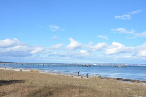 ein Strand mit Menschen und ein Pier im Wasser in der Unterkunft Villa Sirene in Binz