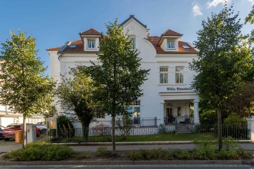 una casa blanca con árboles delante de ella en Villa Annabelle, en Binz