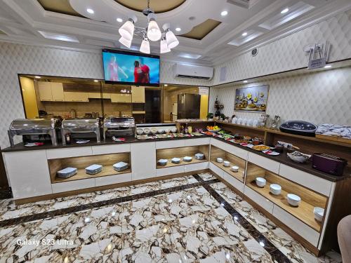 a restaurant with a counter with a buffet at Hotel Sharq in Dushanbe