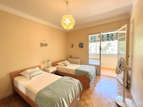 une chambre avec deux lits et un lustre dans l'établissement Appartement le Sicile sanguinaires Ajaccio, à Ajaccio