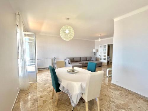 un salon avec une table, des chaises et un canapé dans l'établissement Appartement le Sicile sanguinaires Ajaccio, à Ajaccio