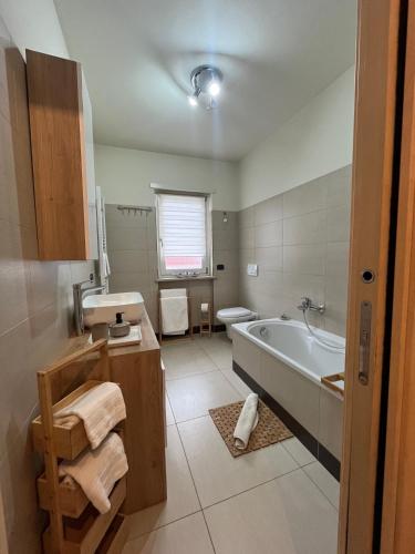 a bathroom with a tub and a toilet and a sink at Apartamento da Jenny in Aosta