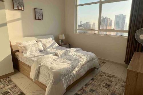 a bedroom with a bed with a large window at شقة في الشارقة in Sharjah