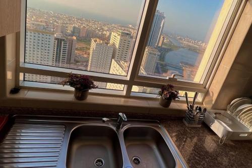 a kitchen sink in front of a large window at شقة في الشارقة in Sharjah