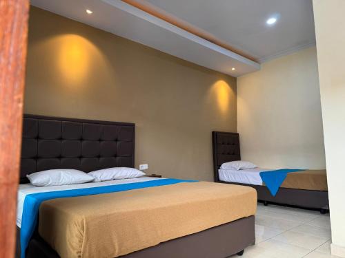 a bedroom with two beds in a room at Hotel Priangan in Cirebon