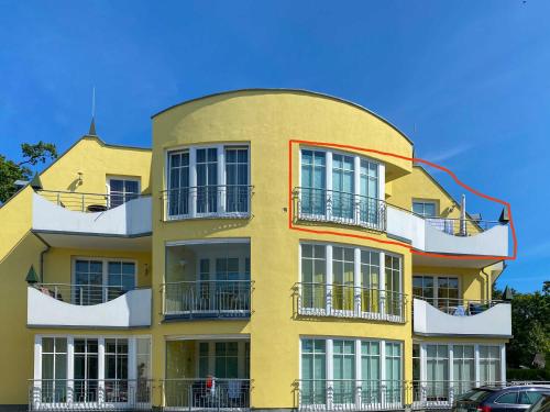a yellow building with balconies on the side of it at Villa Vogelsang Ferienwohnung 10 "Lachmöwe" in Binz