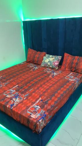 chambre Dakar tres lix في Ngor: سرير لحاف ومخدات حمراء عليه