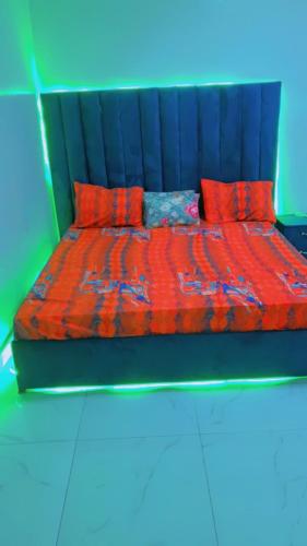 chambre Dakar tres lix في Ngor: سرير مع لحاف ووسائد حمراء
