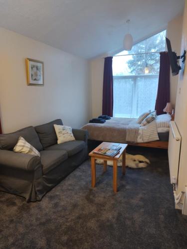 uma sala de estar com um sofá e uma cama em Cartmel em Aultbea